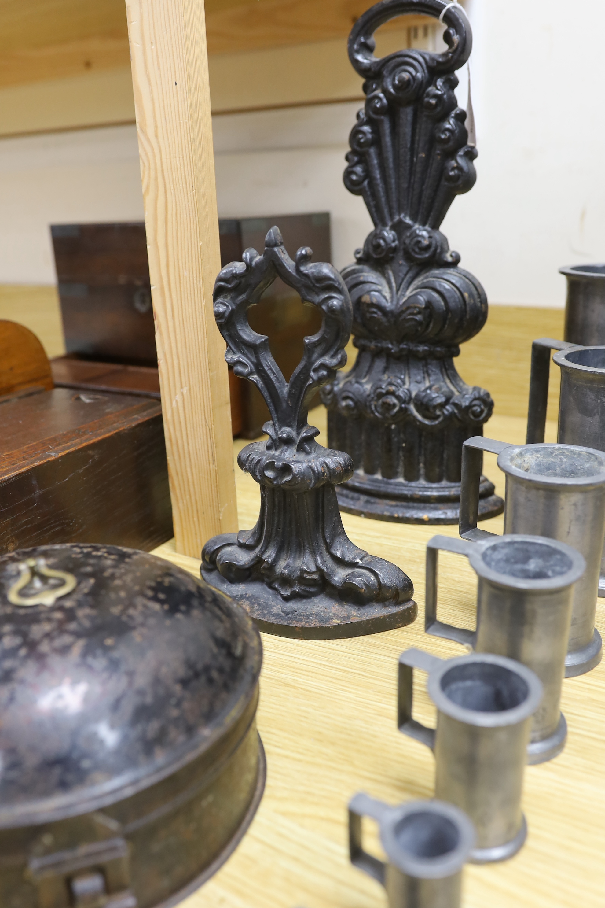 A graduated set of seven French pewter measures, a toleware spice box and two cast iron door stops (10), tallest door stop 39cms high
